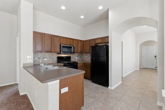 a kitchen with stainless steel appliances granite countertop a refrigerator and a sink