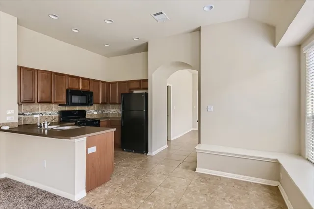 a kitchen with granite countertop a refrigerator and a sink