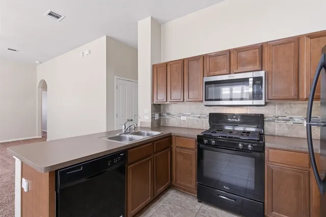 a kitchen with a sink stove and microwave