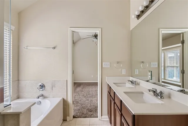 a bathroom with a tub sink double and mirror