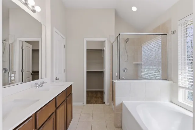 a bathroom with a bathtub shower sink double and mirror