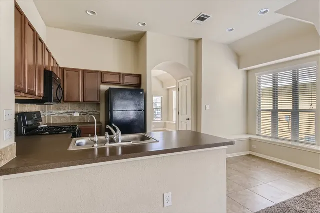 a kitchen with stainless steel appliances granite countertop a sink refrigerator and microwave