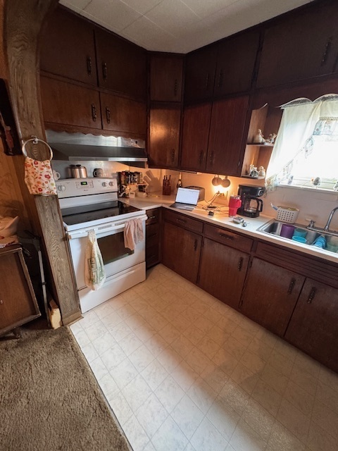 401 Adams Street Humboldt, IL 61931 - Photo 17 of 18 a kitchen with stainless steel appliances granite countertop a sink a stove and a microwave oven