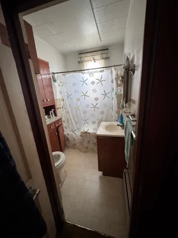 a bathroom with a sink and mirror with bathtub