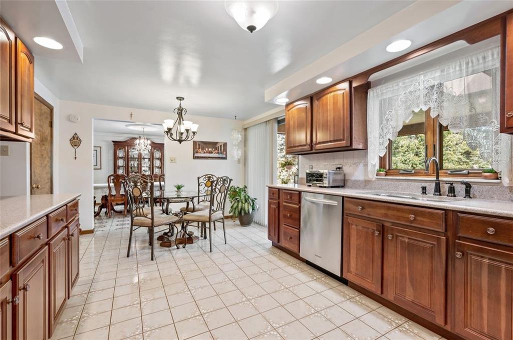 236 Philander Street Pittsburgh, PA 15218 - Photo 13 of 35 a kitchen with stainless steel appliances granite countertop a refrigerator a sink dishwasher a dining table and chairs with wooden floor