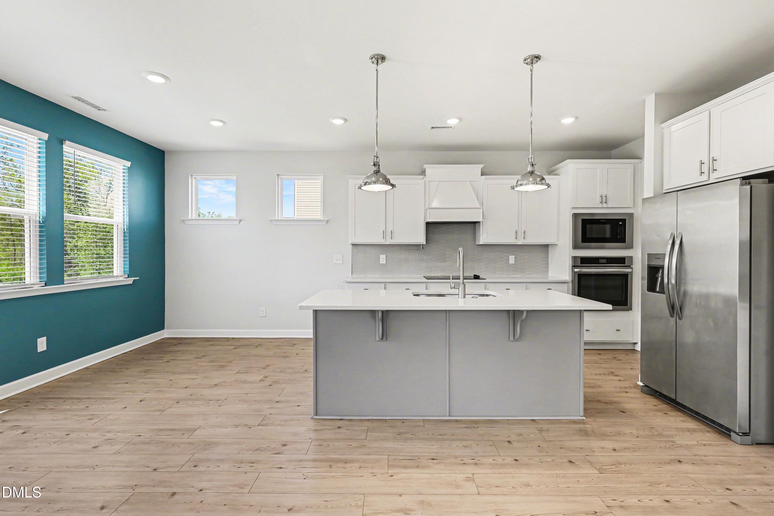 90 Rigsby Avenue Four Oaks, NC 27524 - Photo 12 of 43 a kitchen with kitchen island a sink stainless steel appliances and cabinets