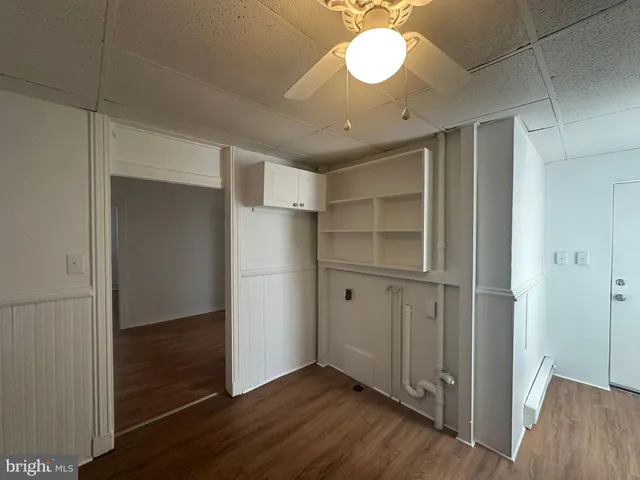 a kitchen with stainless steel appliances granite countertop a refrigerator a sink dishwasher a stove and white countertops with wooden floor