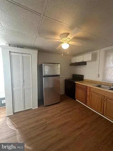 a kitchen with granite countertop a stove cabinets and wooden floor