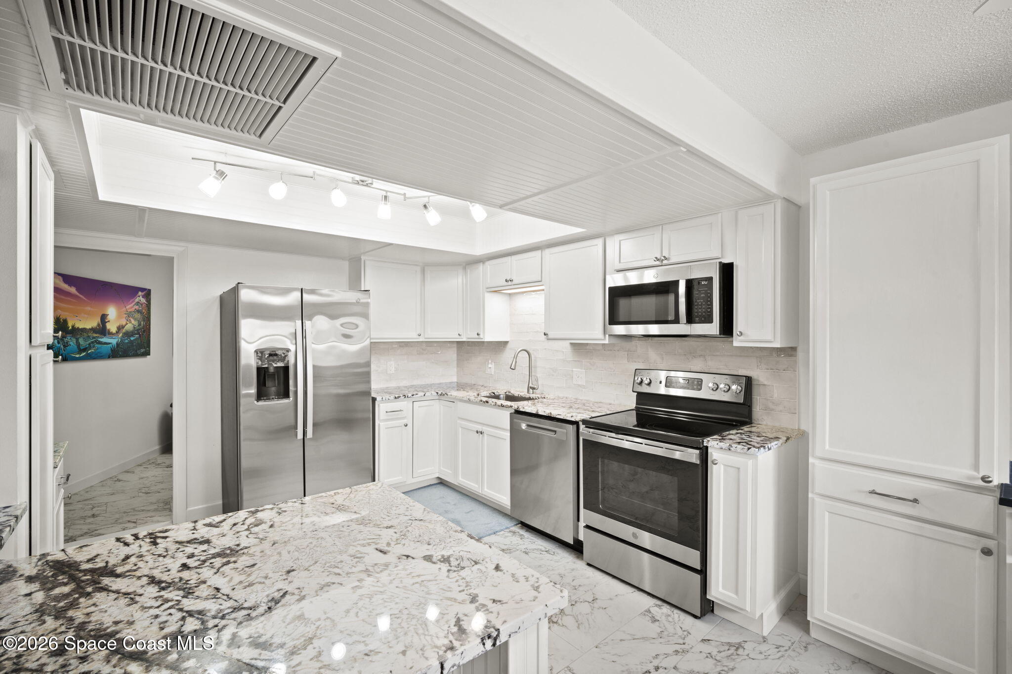 1505 South Carpenter Road Titusville, FL 32796 - Photo 11 of 36 a kitchen with stainless steel appliances kitchen island granite countertop a stove a refrigerator and a sink