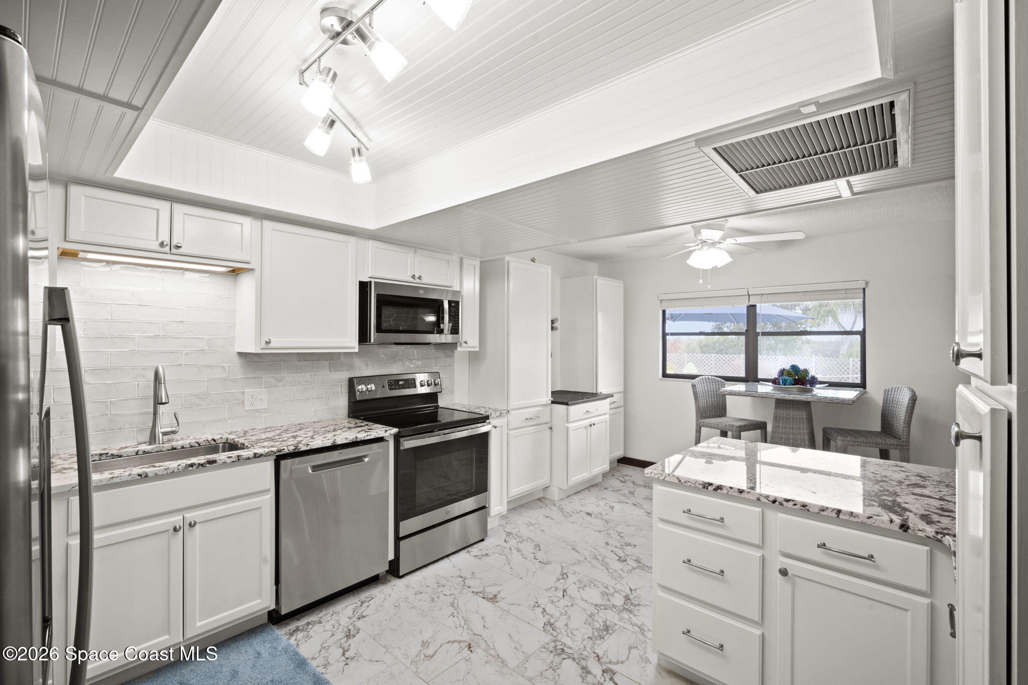1505 South Carpenter Road Titusville, FL 32796 - Photo 12 of 36 a kitchen with a sink stainless steel appliances and white cabinets