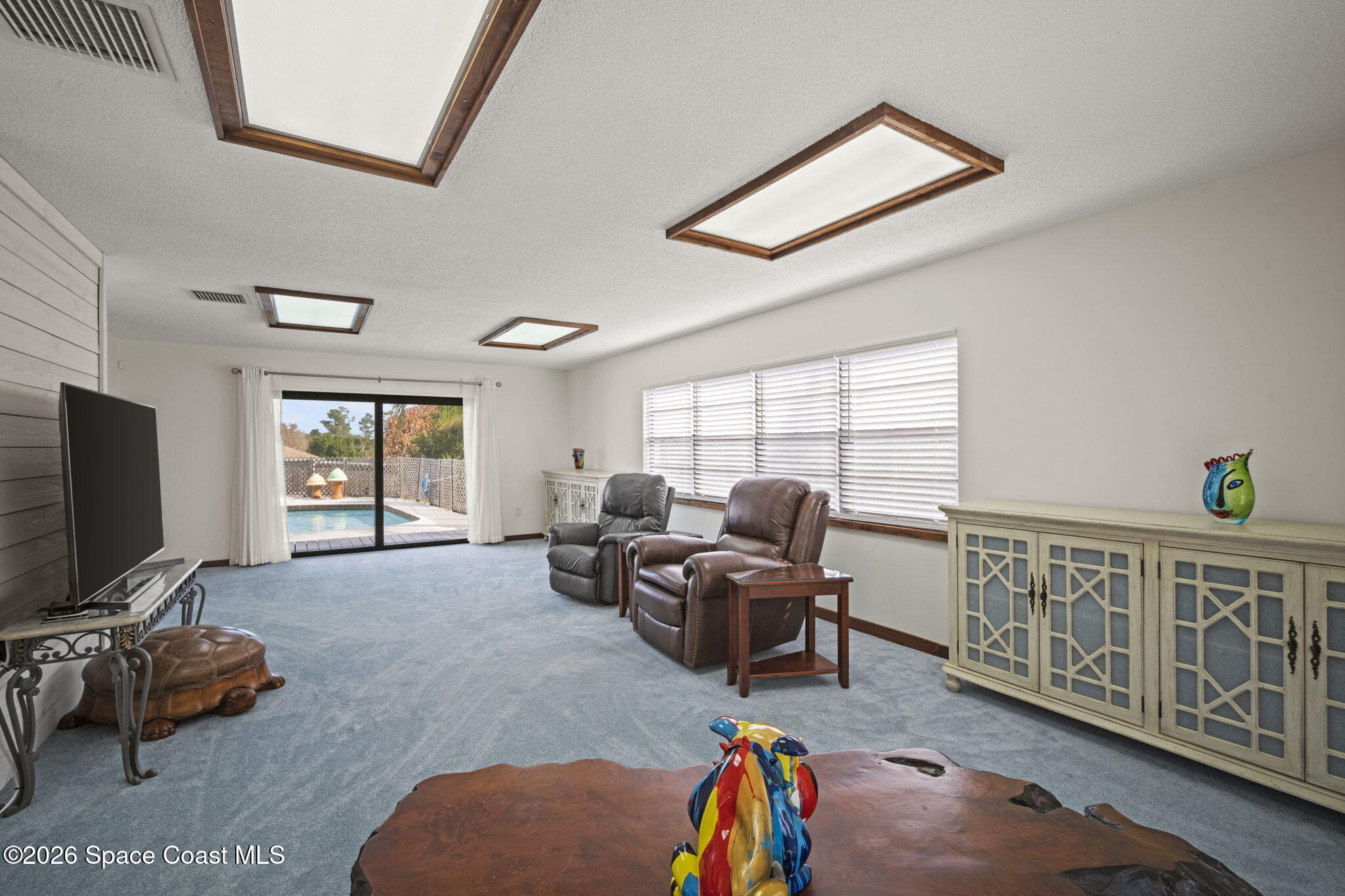 1505 South Carpenter Road Titusville, FL 32796 - Photo 14 of 36 a living room with furniture a flat screen tv and a large window