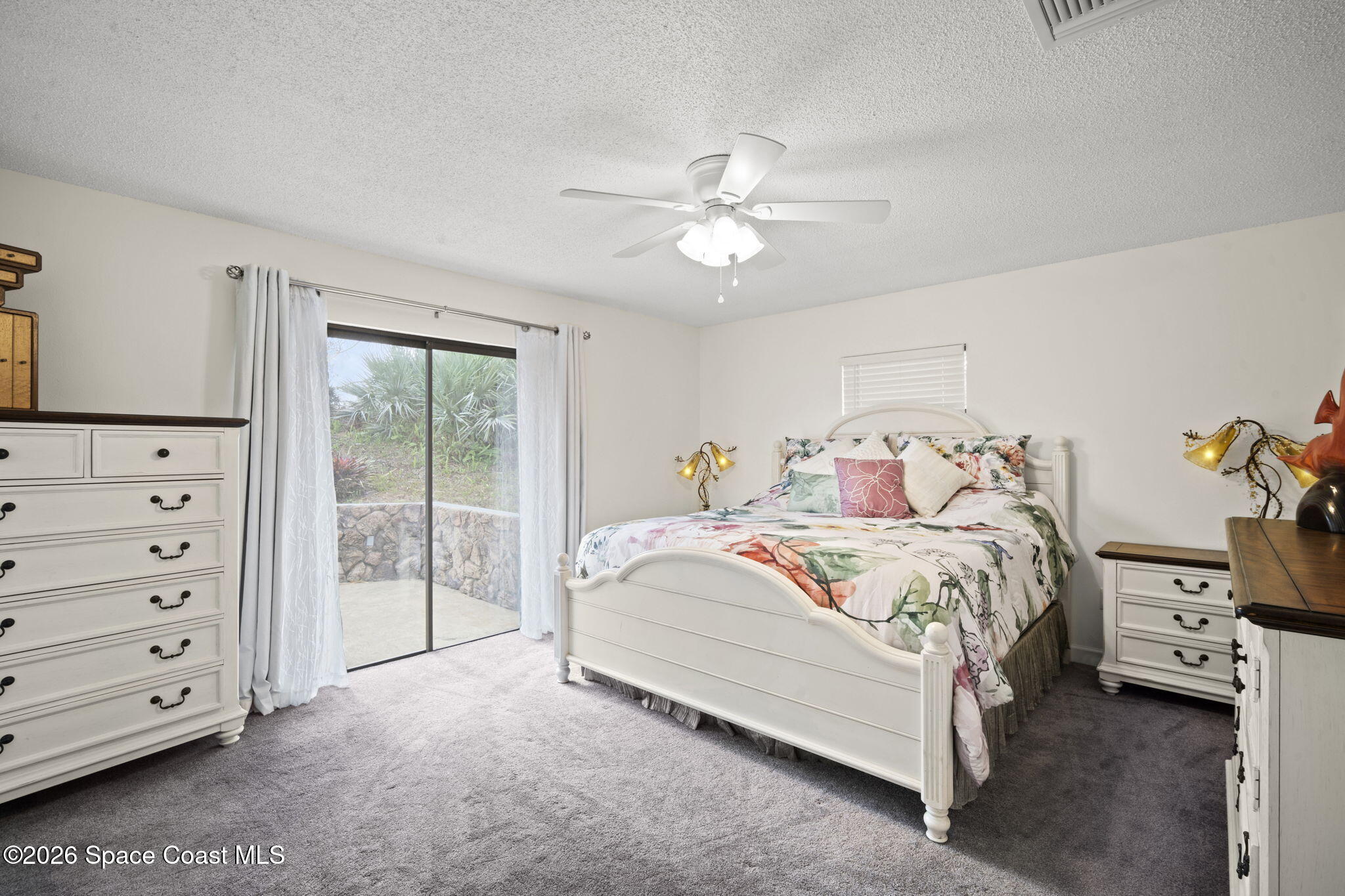 1505 South Carpenter Road Titusville, FL 32796 - Photo 15 of 36 a spacious bedroom with a bed and a chandelier