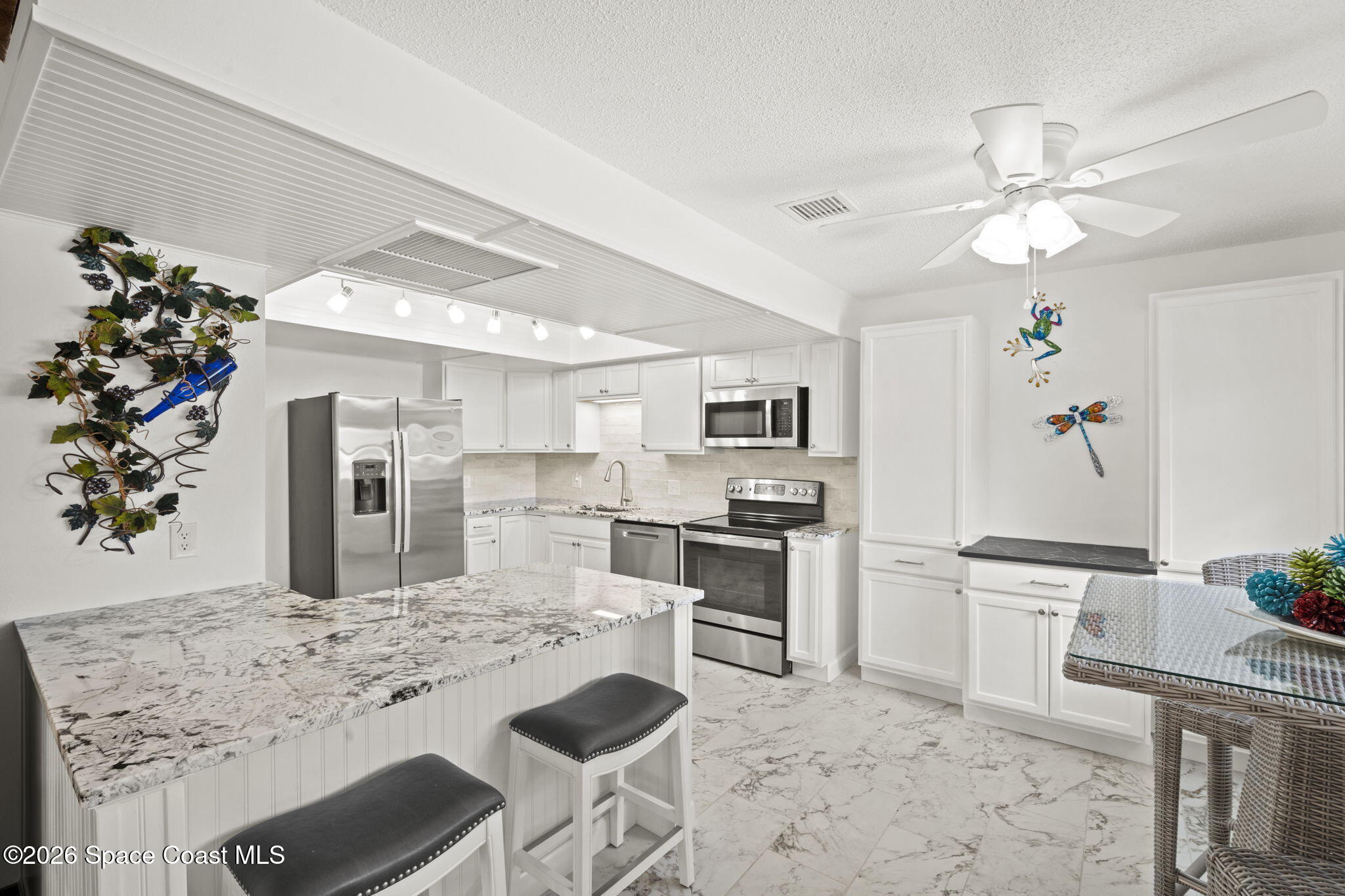 1505 South Carpenter Road Titusville, FL 32796 - Photo 9 of 36 a kitchen with kitchen island granite countertop a sink cabinets stainless steel appliances and a chandelier