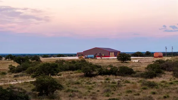 an aerial view of a house with a yard and mountain view in back