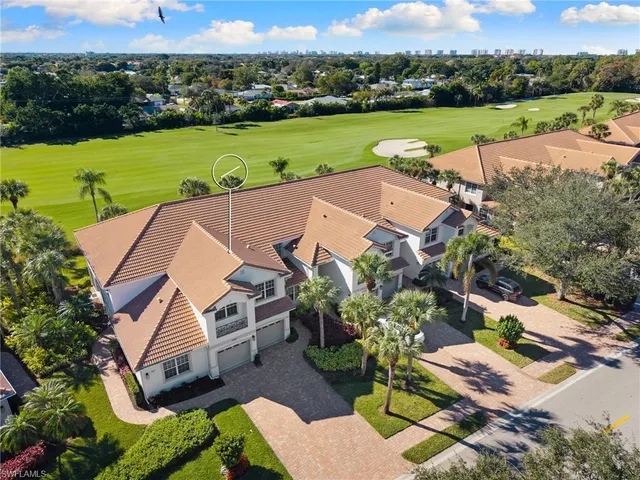an aerial view of a city with lots of residential buildings ocean and mountain view in back