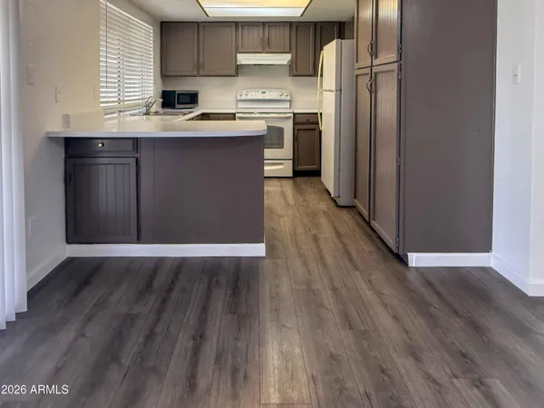 a view of a room with wooden floor and a window