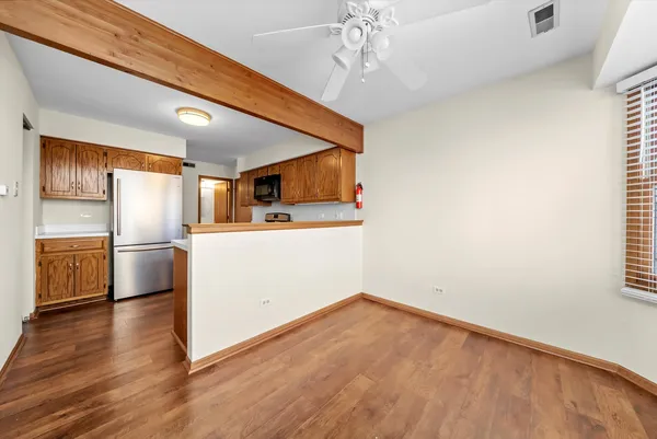 a view of a kitchen with a sink refrigerator and wooden floor