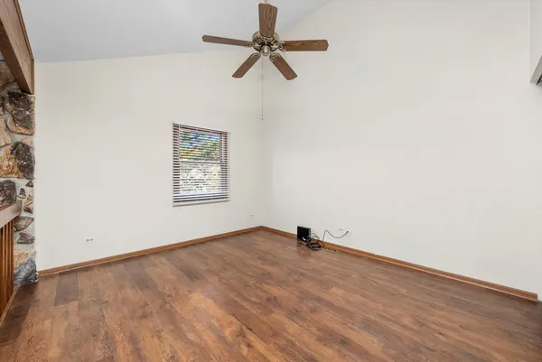 a view of room with a ceiling fan and wooden floor
