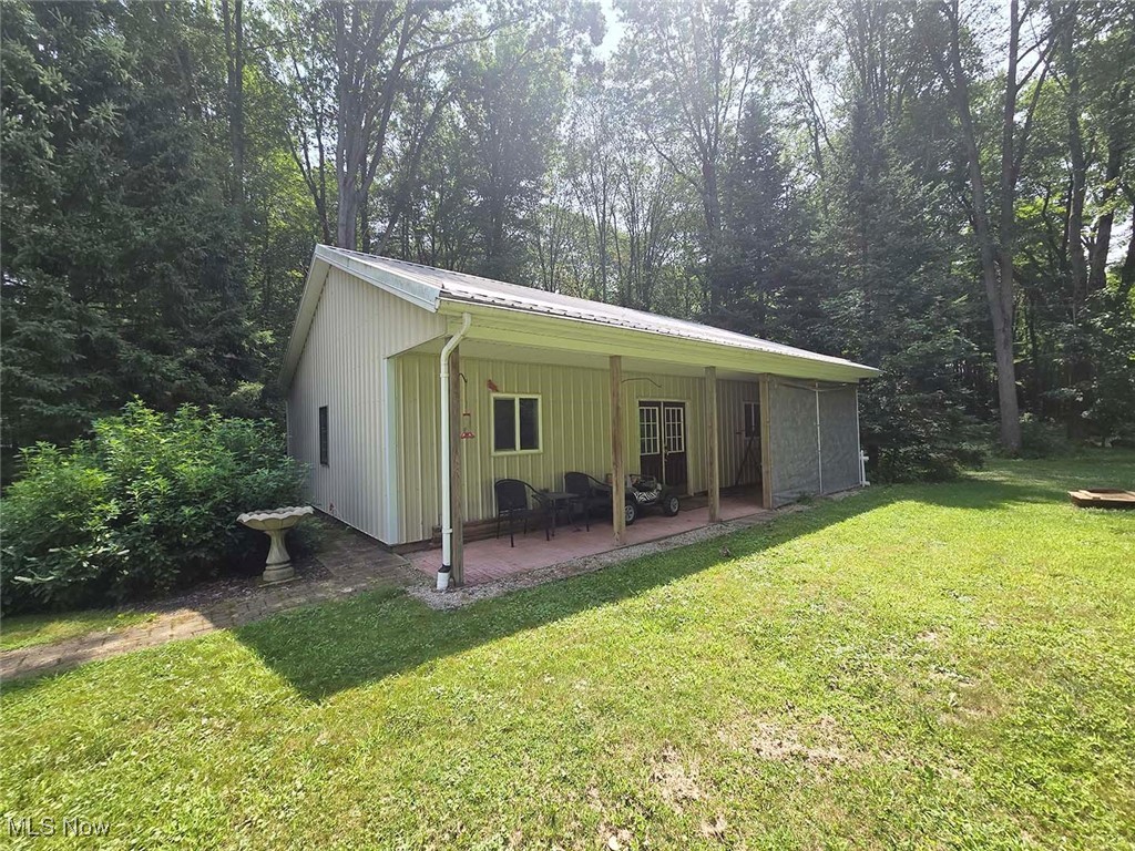 4380 Harner Road Mantua, OH 44255 - Photo 3 of 19 Rear view of house with a yard and view of wooded area