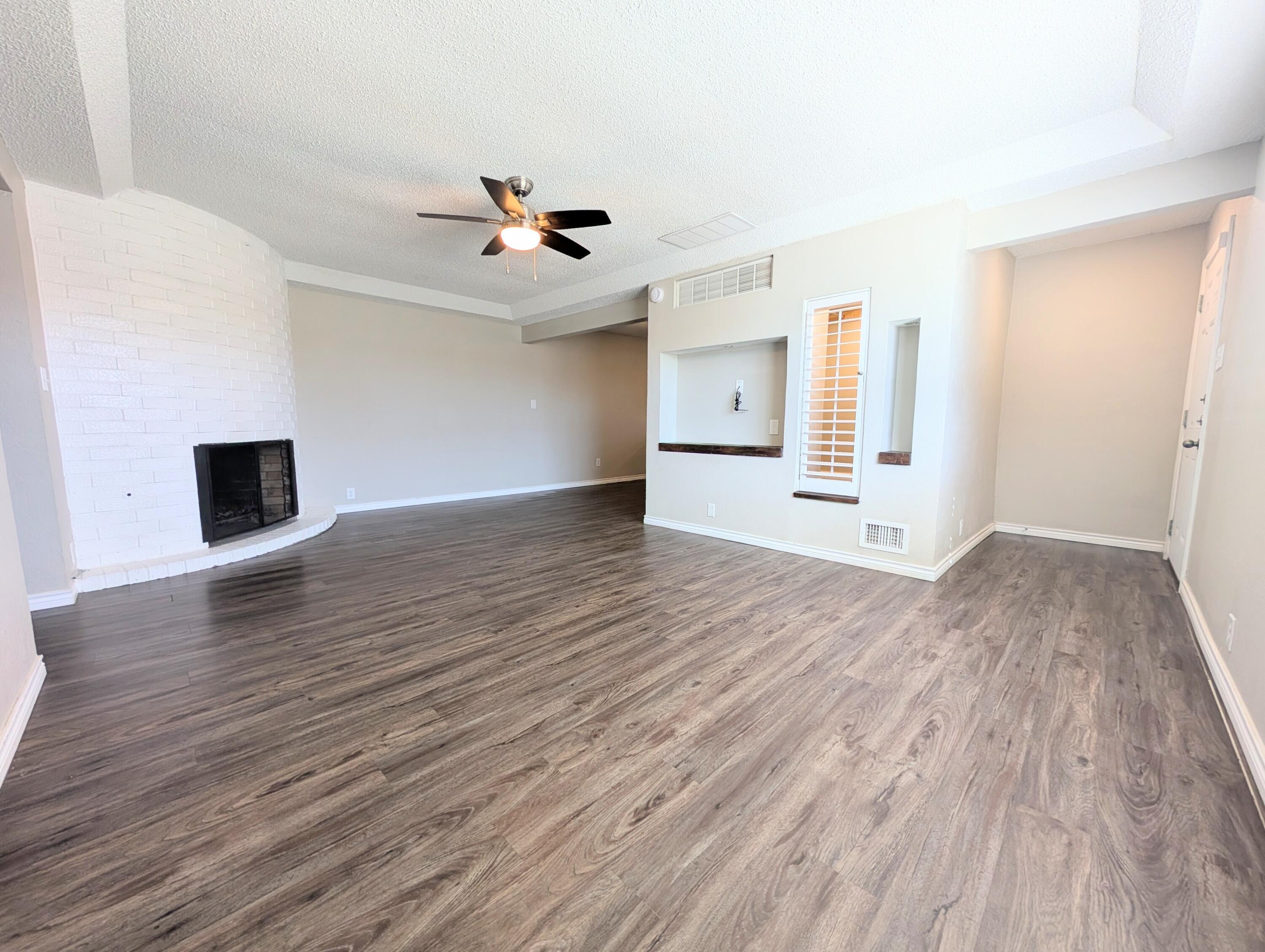 5201 18th Street, Unit A Lubbock, TX 79416 - Photo 5 of 10 wooden floor in an empty room with a window
