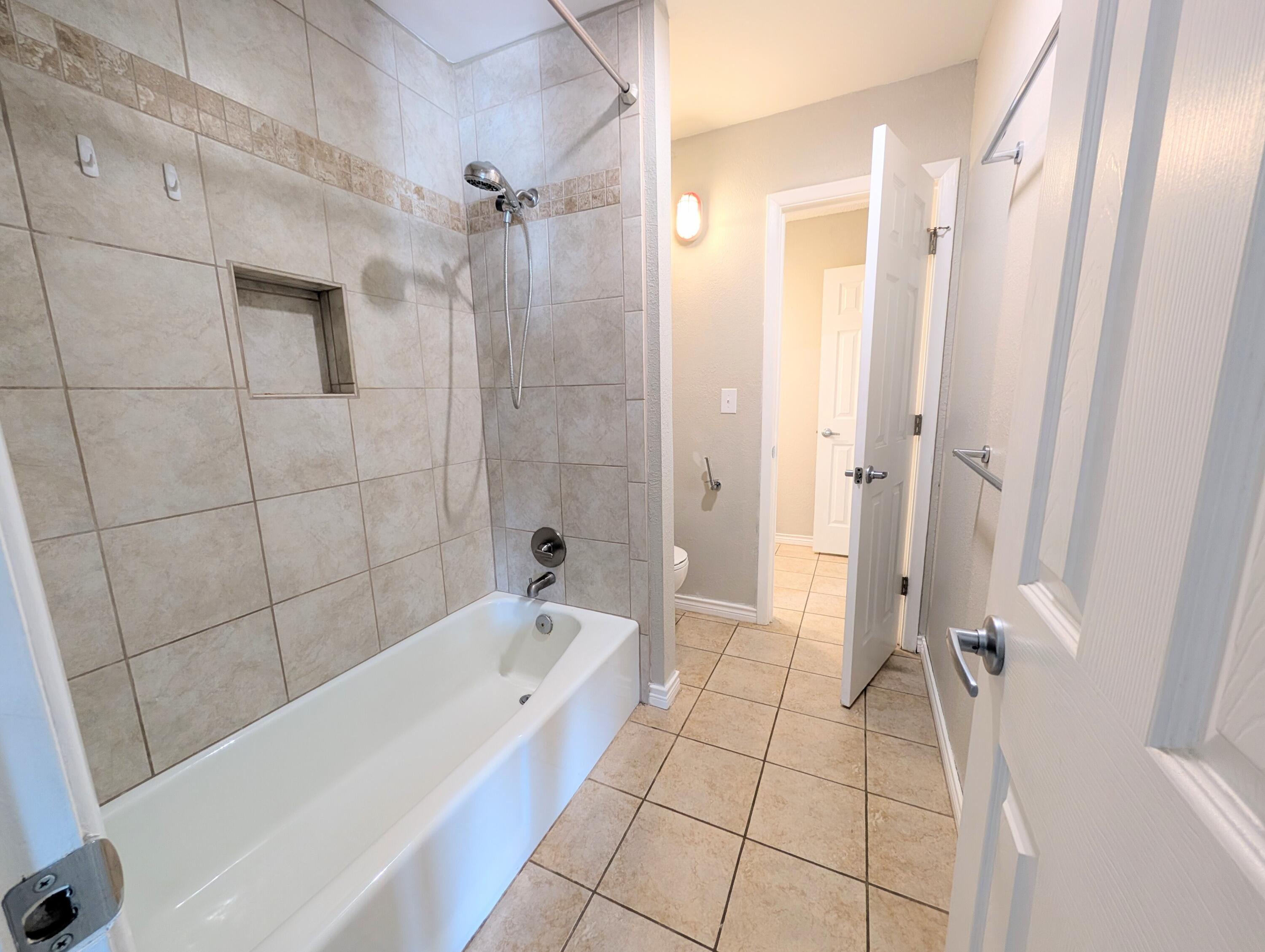 5201 18th Street, Unit A Lubbock, TX 79416 - Photo 10 of 10 a bathroom with a bathtub and shower