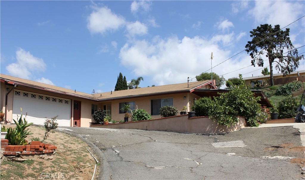 a view of a house with potted plants and a large tree