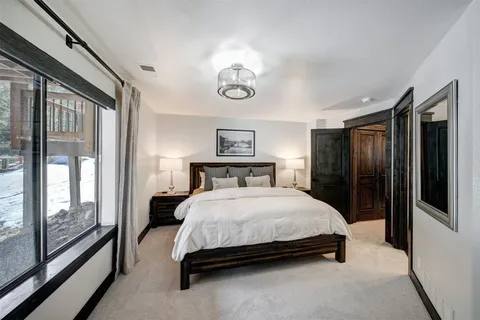 a bedroom with a large bed and a chandelier