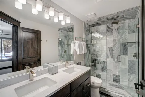 a bathroom with a sink a toilet and shower