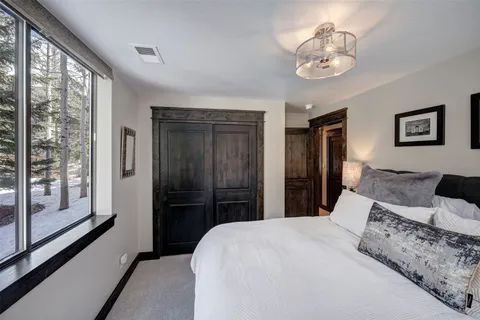 a bedroom with a large bed and a chandelier