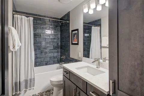 a bathroom with a sink toilet vanity and shower
