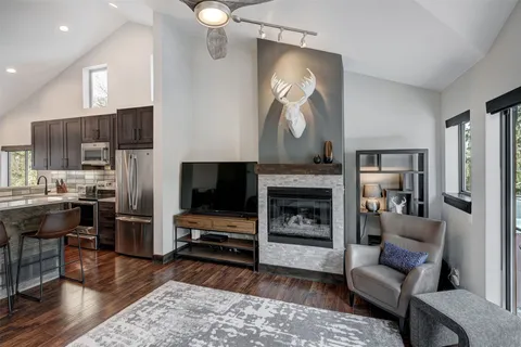 a living room with furniture a flat screen tv and a fireplace