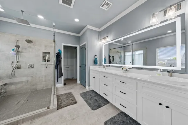a bathroom with a double vanity sink mirror and shower