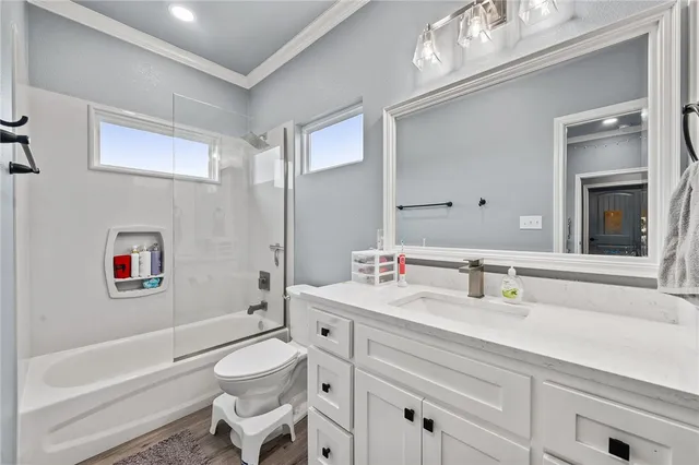 a bathroom with a granite countertop toilet sink and mirror