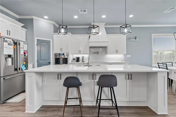 a kitchen with kitchen island granite countertop a sink a center island stainless steel appliances and cabinets