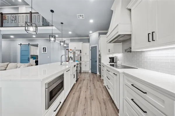 a large white kitchen with stainless steel appliances