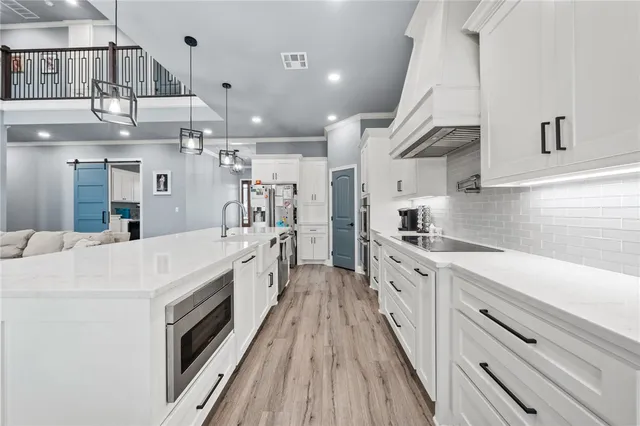 a large white kitchen with stainless steel appliances