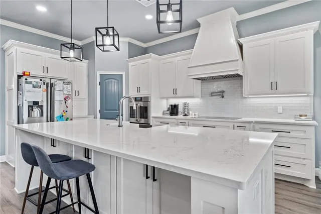 a kitchen with stainless steel appliances a sink a stove and a refrigerator