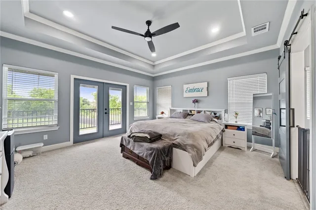 a spacious bedroom with a bed a ceiling fan and a large window