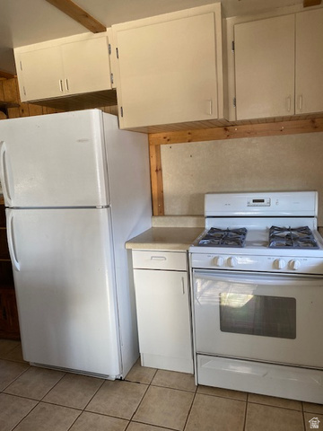 913 East 5300 North Helper, UT 84526 - Photo 8 of 29 Kitchen with white appliances, white cabinets, light countertops, and light tile patterned floors