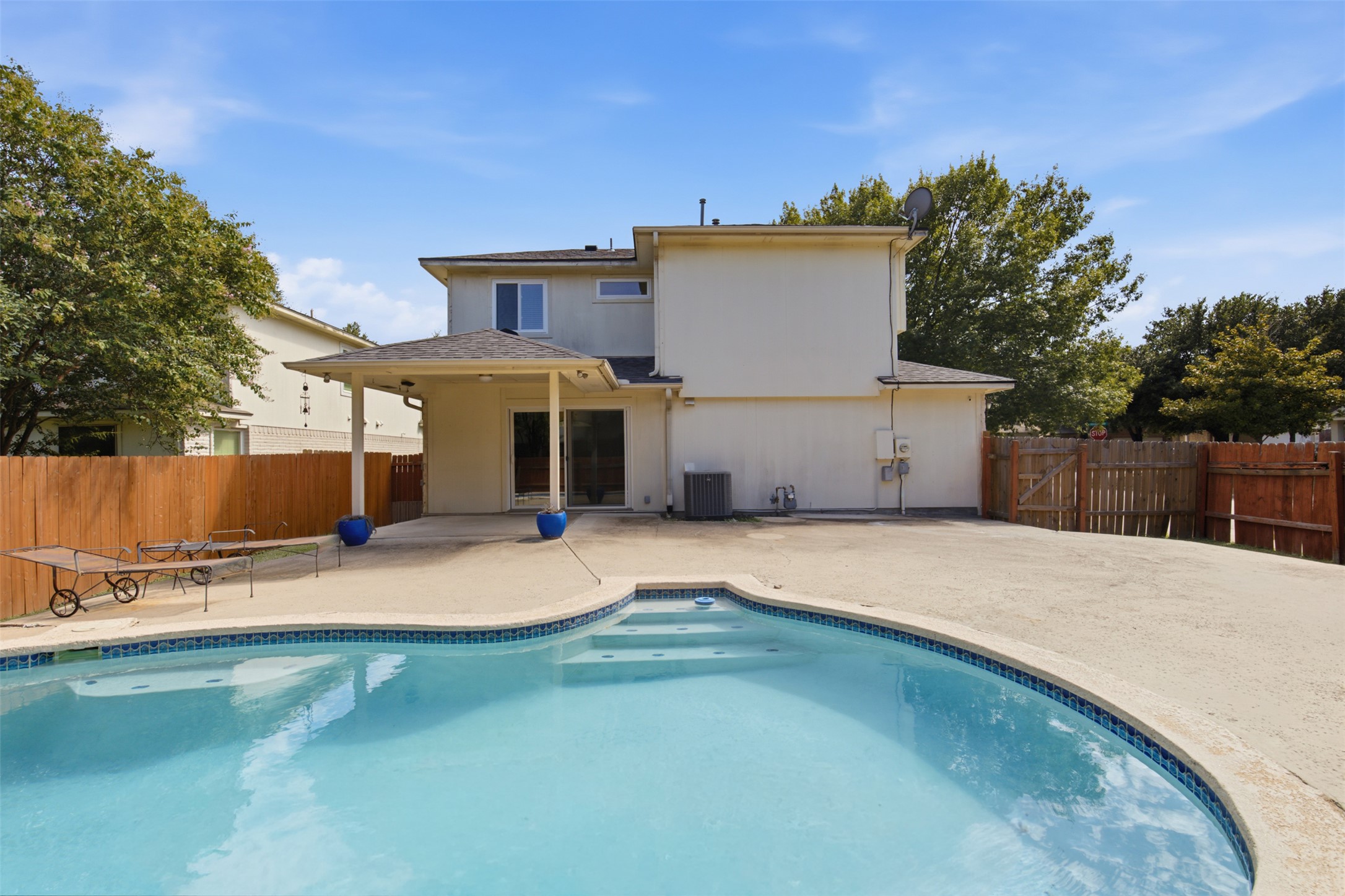 1416 Roxanne's Run Pflugerville, TX 78660 - Photo 28 of 35 An inviting backyard oasis features a shimmering in-ground pool and ample concrete patio space, ideal for outdoor leisure.