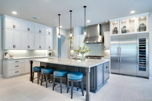 a kitchen with granite countertop a sink a stove and a refrigerator