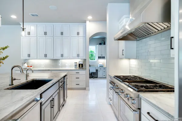 a kitchen with granite countertop a table chairs stove and cabinets