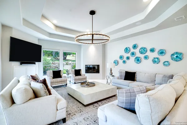 a living room with furniture a flat screen tv and a large window