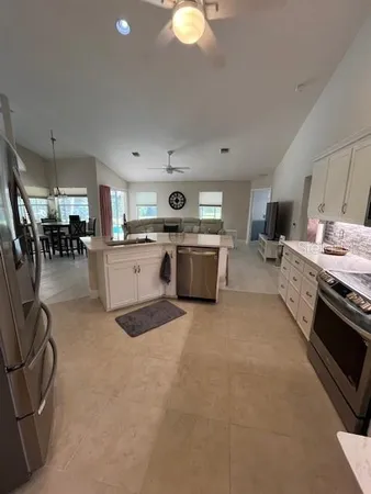 a living room with furniture and kitchen view