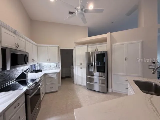 a room with stainless steel appliances a sink a table and chairs