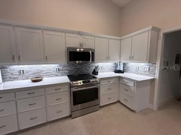 a kitchen with kitchen island a table and chairs in it