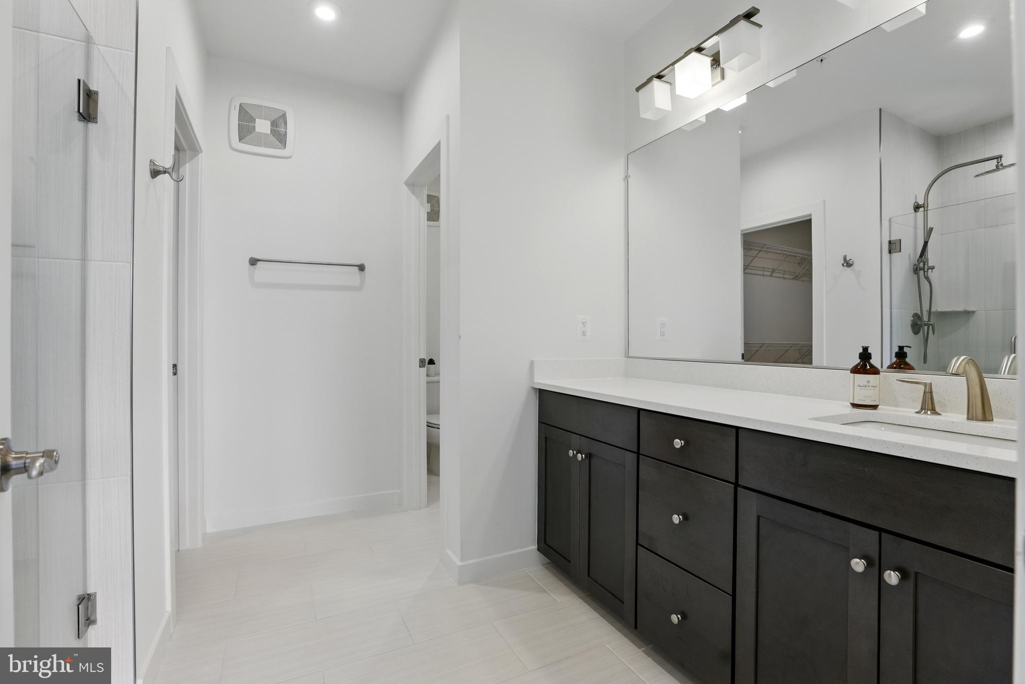 4140 Legato Road, Unit 47 Fairfax, VA 22033 - Photo 15 of 23 a bathroom with a double vanity sink a mirror and a shower