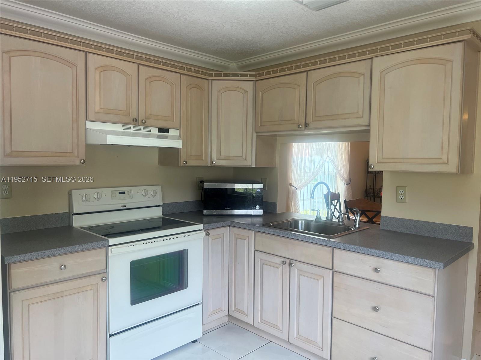 5827 Northwest 197th Terrace Hialeah, FL 33015 - Photo 14 of 30 a kitchen with white cabinets and white appliances