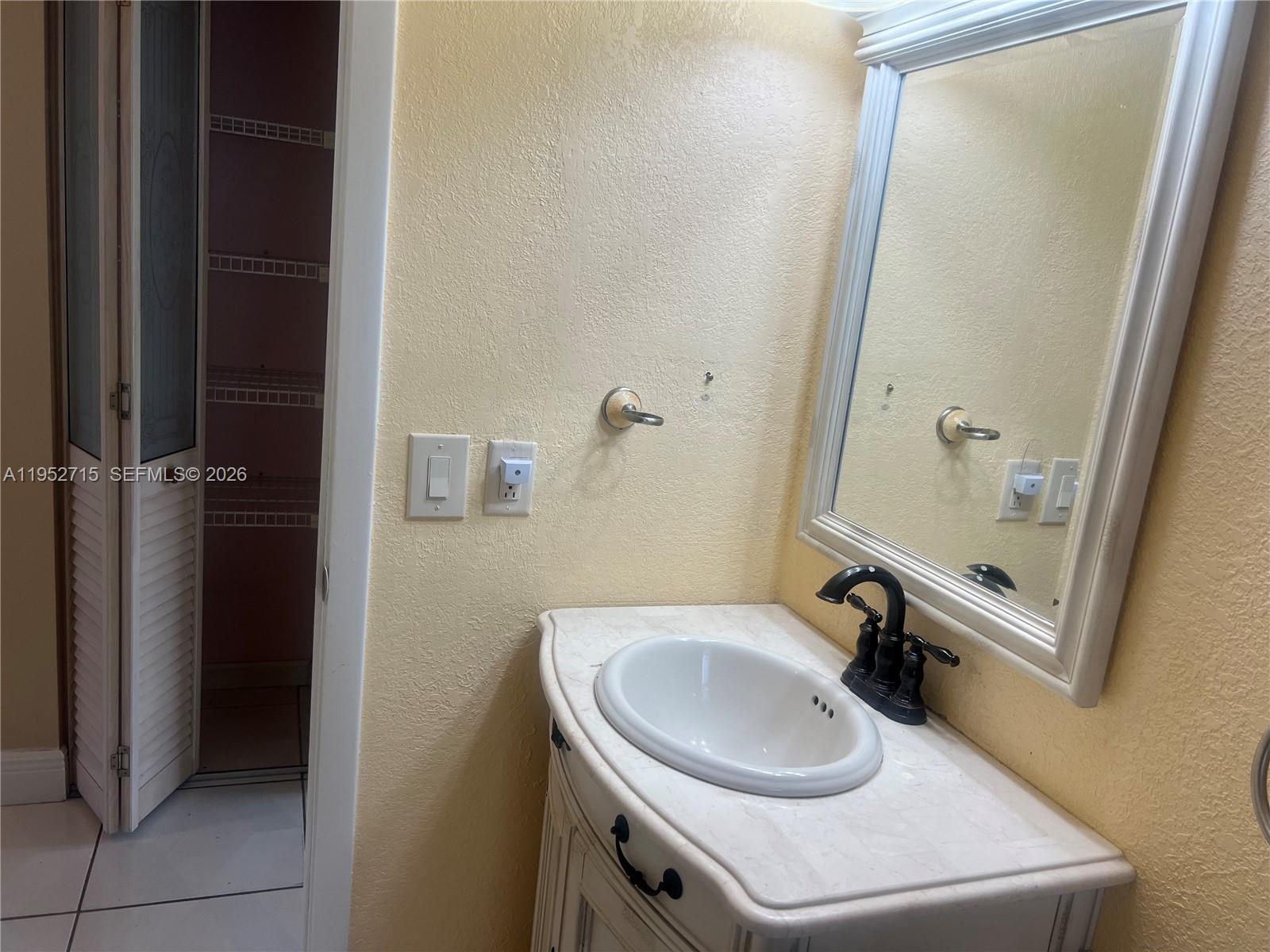5827 Northwest 197th Terrace Hialeah, FL 33015 - Photo 25 of 30 a bathroom with a sink and a mirror
