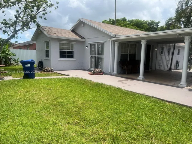 a front view of a house with yard and green space